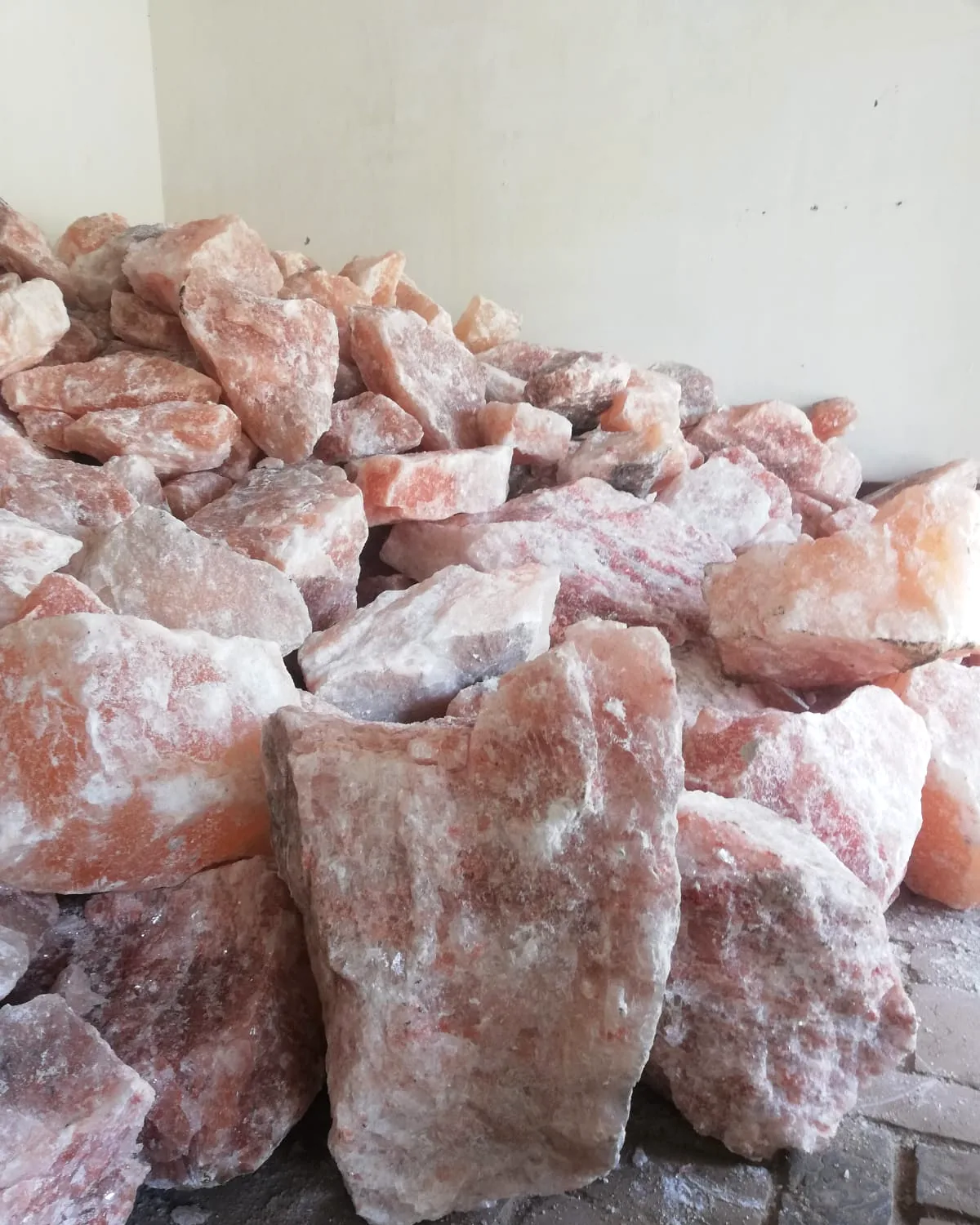 Raw Himalayan pink salt chunks at the AAA Trade House plant, showing natural colour variation from pale to deep pink